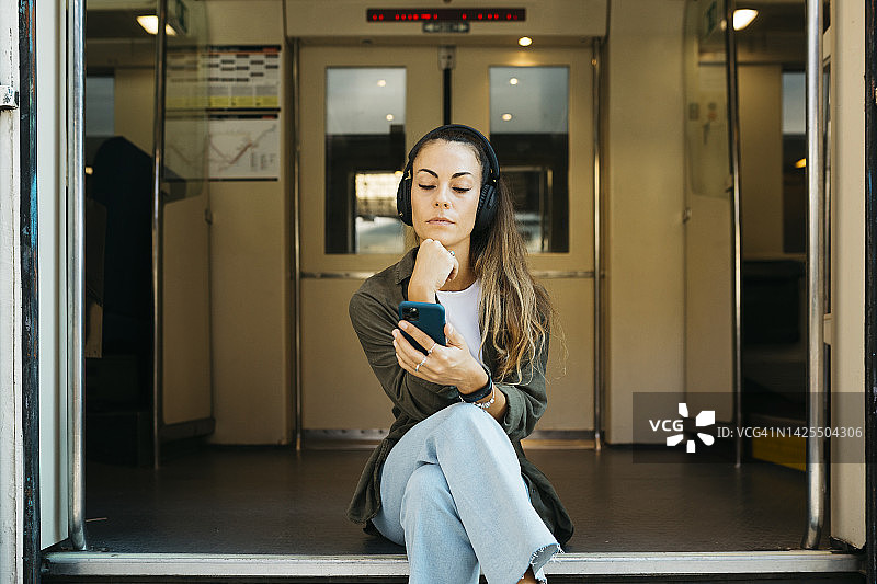 火车上戴耳机的女人图片素材