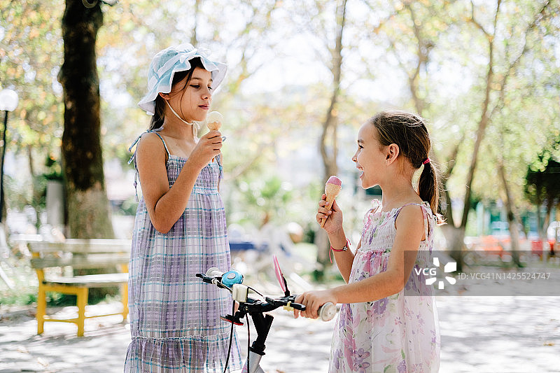 夏天在户外吃冰淇淋的小女孩的画像图片素材