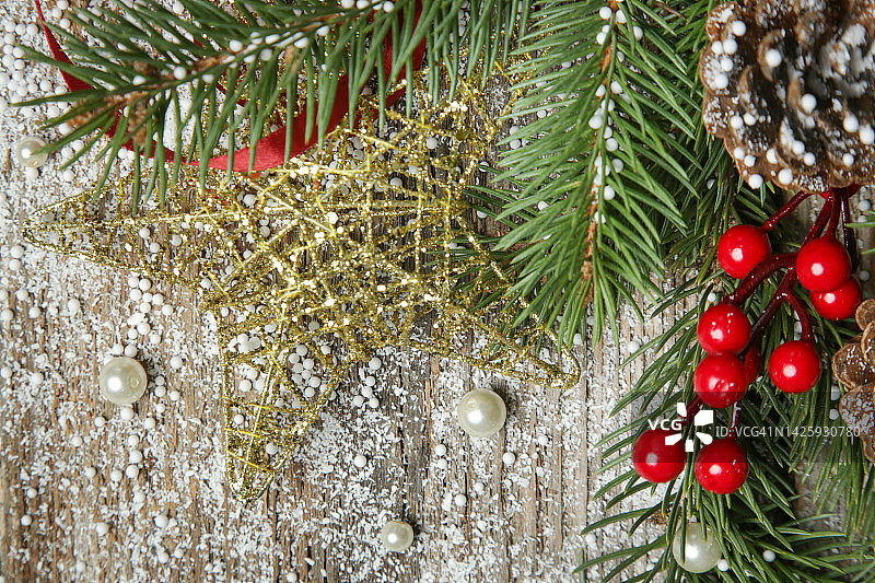 圣诞树的树枝，针叶树球果和红色浆果-顶视图复制空间在旧的木制背景。圣诞节，寒假，新年的概念。图片素材