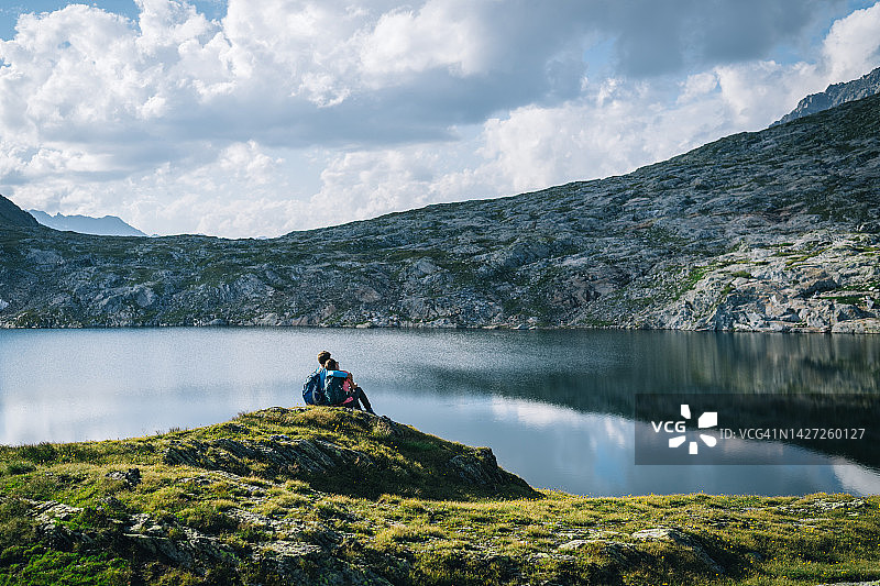 徒步旅行的情侣在高山湖上放松图片素材