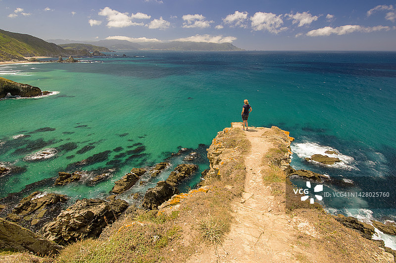 一名女子在西班牙阿Coruña奥尔蒂盖拉的Loiba悬崖上欣赏风景。图片素材