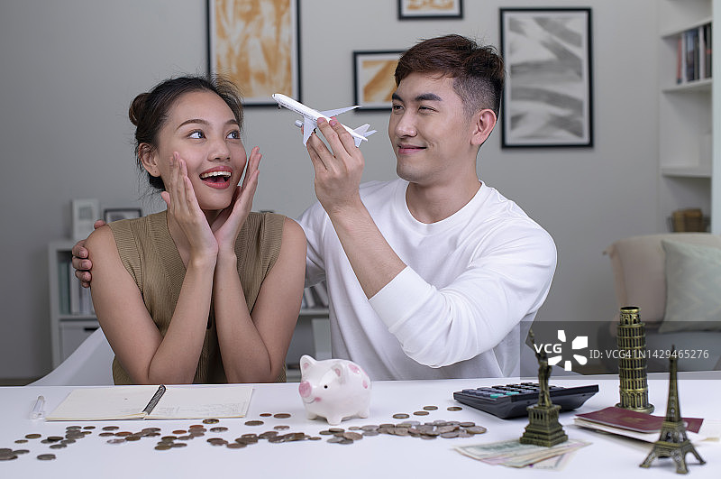 一对年轻的亚洲夫妇计划攒钱环游世界。图片素材