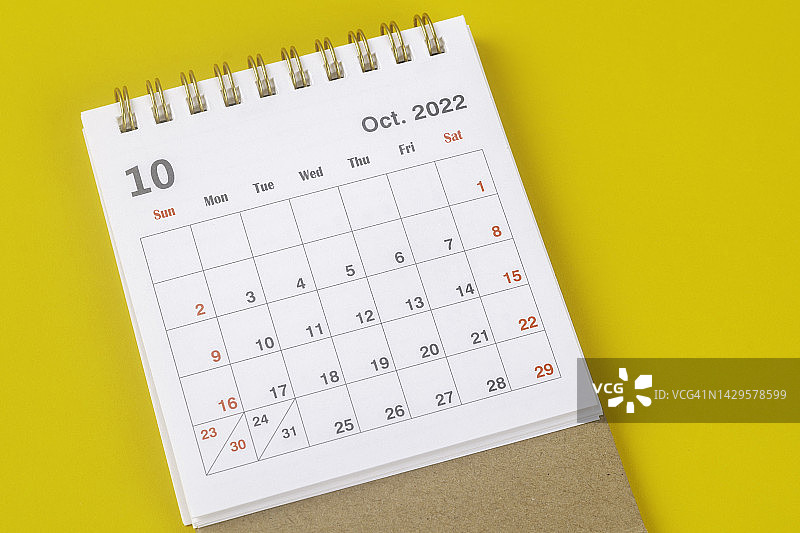 2022年日历台:10月是组织者计划和截止日期的月份，背景是黄色的纸。图片素材