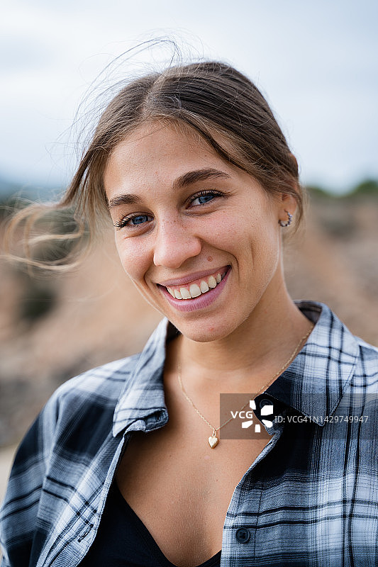 一个年轻的西班牙妇女的特写肖像微笑，看着相机图片素材