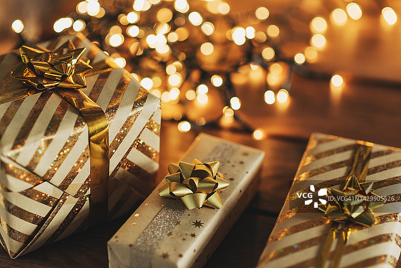 一个咖啡桌与圣诞装饰模糊的背景沙发和圣诞树与花环灯在舒适的房间与壁炉和新年的装饰。圣诞鹿和冷杉果。图片素材