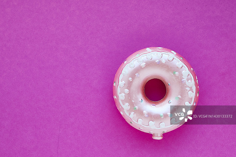 粉色背景上的甜甜圈玩具图片素材