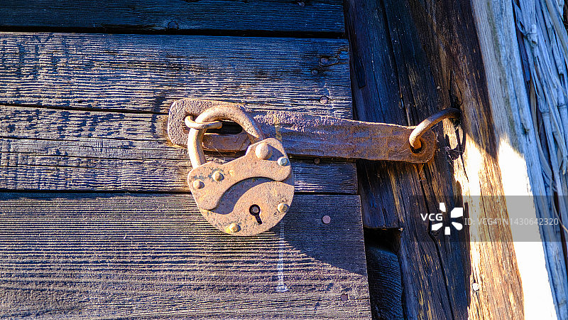 古老的大门锁。旧木门锁着。图片素材