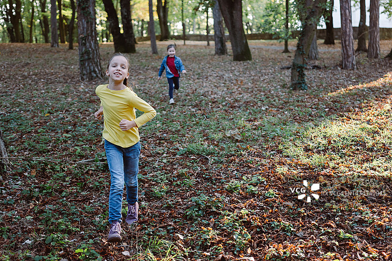 女孩在秋天的公园里跑步图片素材