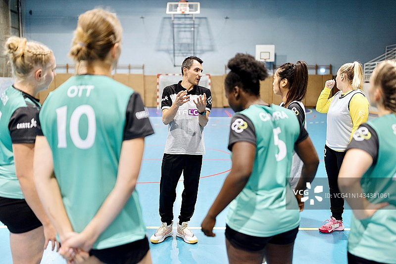 女手球教练和他的队员谈论比赛策略图片素材