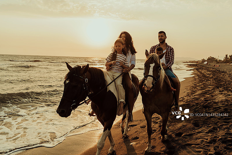 一家人和孩子们一起在沙滩上骑马。有选择性的重点图片素材