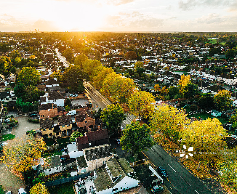 日落时郊区房屋和道路的空中秋景图片素材