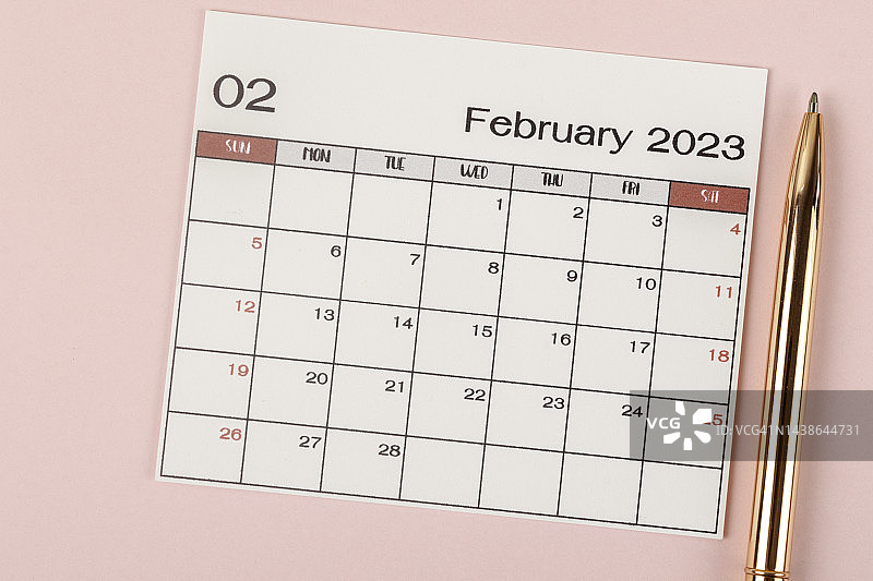 2023日历台:家庭办公室手工制作。二月是组织者在灰纸背景下用笔计划和截止日期的月份。图片素材