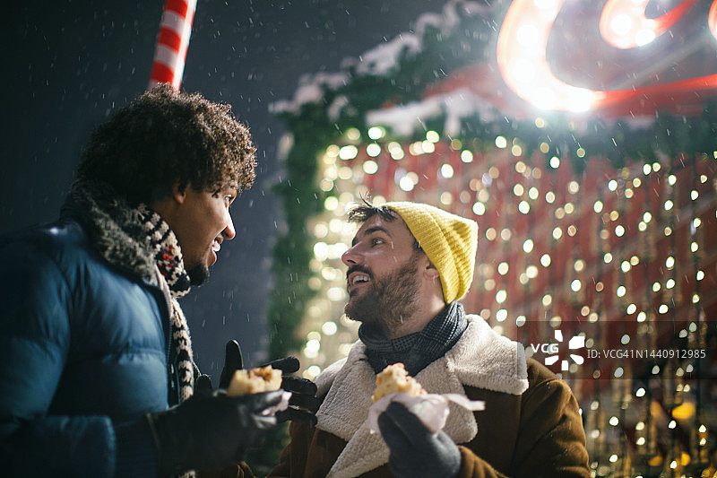 朋友们在冬夜享受街头小吃。图片素材
