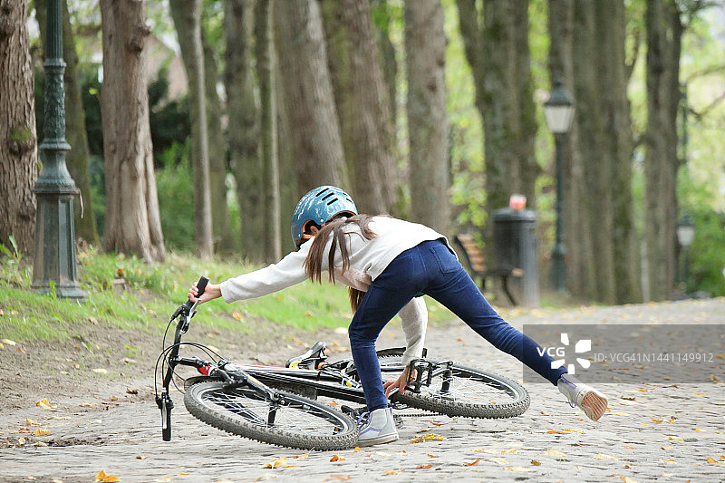 混血少年。她抬起她的自行车。图片素材