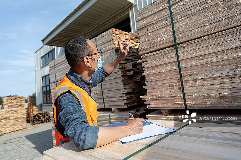 一位亚洲男性工程师在一家木材加工厂工作图片素材
