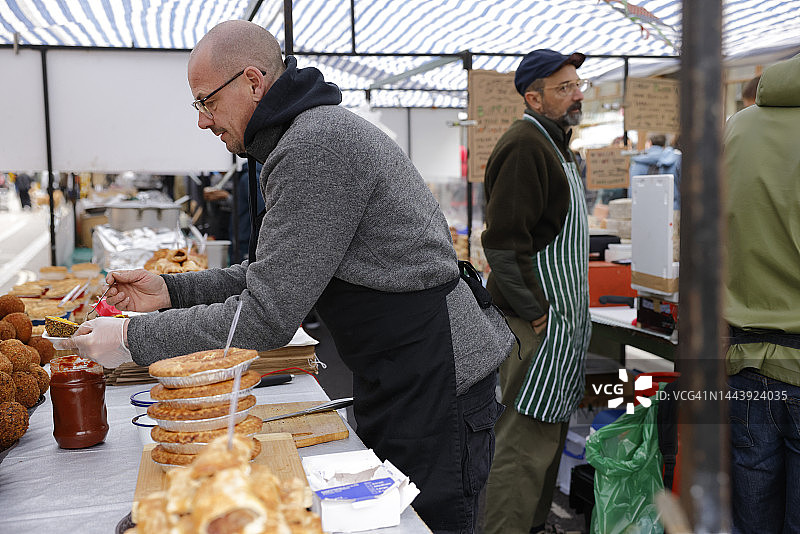 一名男子在伦敦街头市场准备食物图片素材