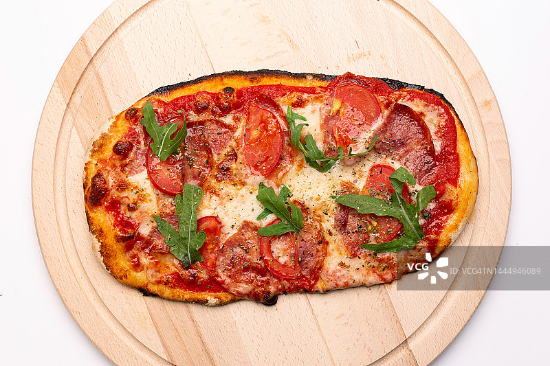 美味的披萨装在木制盘子里。为餐厅或披萨店的广告传单和海报的概念，模板与美味的意大利辣香肠的味道。图片素材