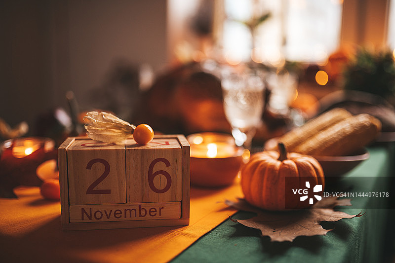 感恩节餐桌上的南瓜和木制日历的秋天装饰图片素材