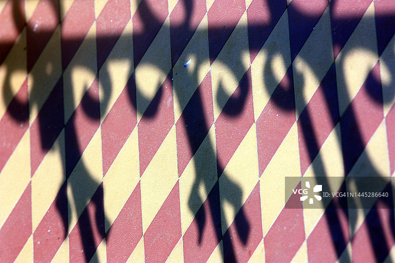 彩色陶瓷地板上的铁网格细节阴影图片素材