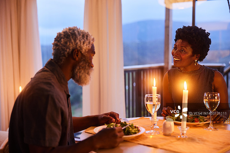 一对夫妻在家里的烛光晚餐上谈笑风生图片素材