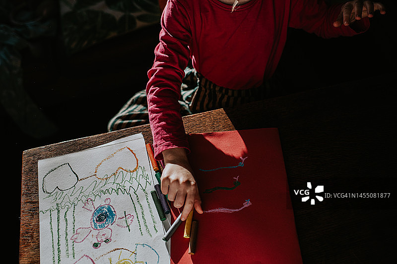 一个孩子用彩色蜡笔画画图片素材