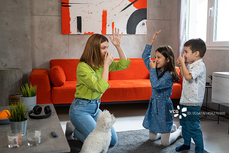 幸福的家庭在家里的客厅里随着音乐跳舞图片素材