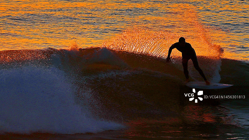 冲浪者在日落时分在加利福尼亚乘风破浪图片素材