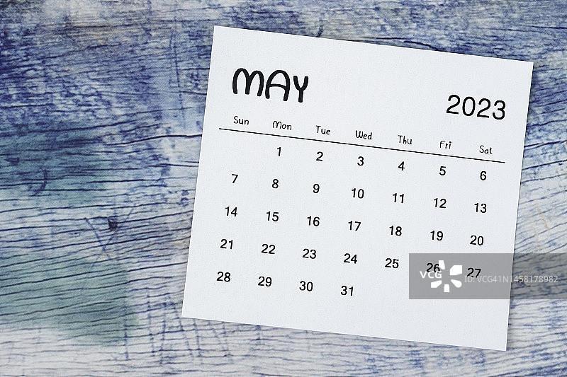 日历台2023:五月是组织者计划和最后期限的月份，蓝色木制背景。图片素材
