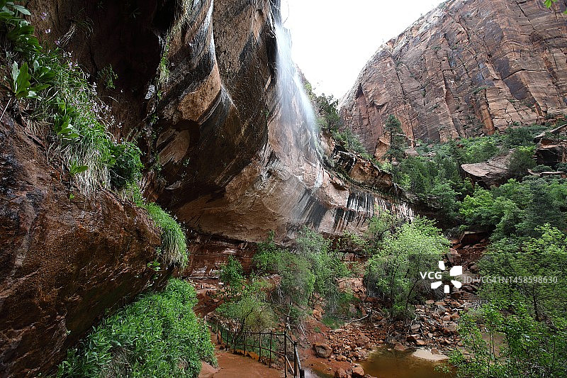 悬崖瀑布下的徒步小径图片素材
