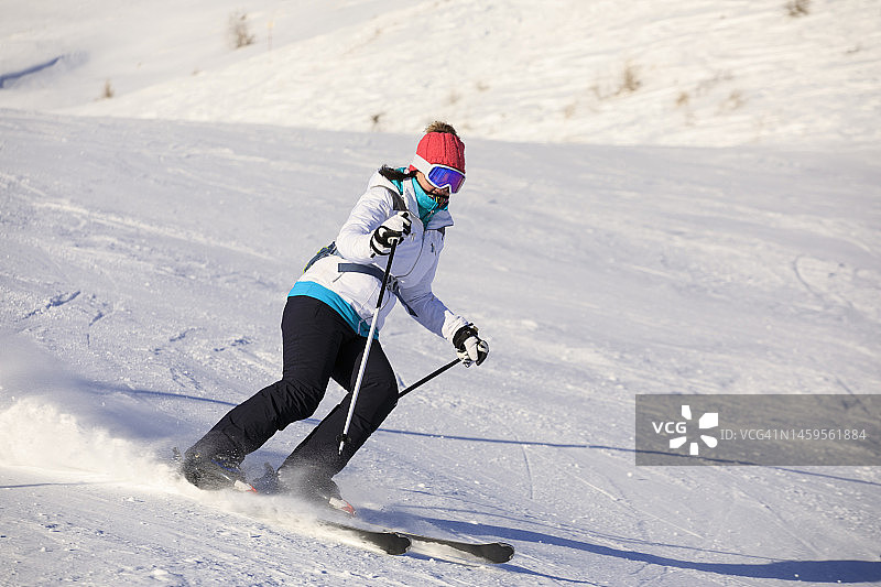 冬季运动高山滑雪。女子滑雪者在滑雪场滑雪雕刻。高山雪山欧洲阿尔卑斯山图片素材