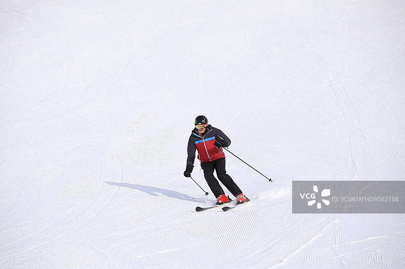男子滑雪者滑雪，享受在滑雪场。高速滑雪雕刻。高山雪景。欧洲阿尔卑斯山脉图片素材