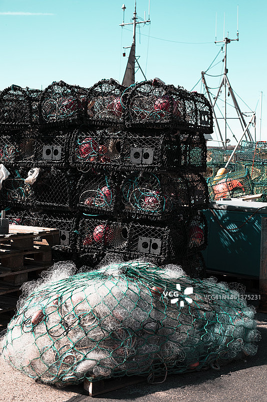 渔网堆放在港口的码头上，特写背景渔网和船图片素材