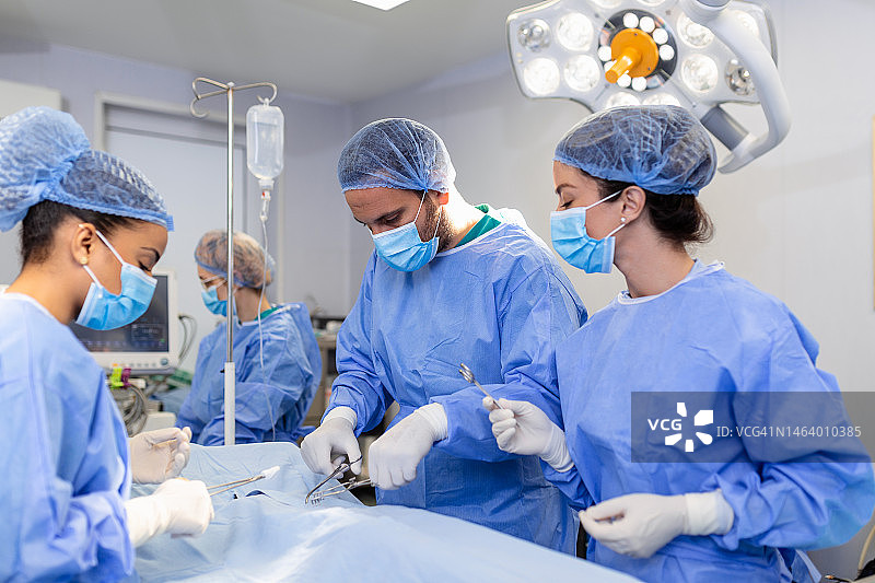 手术操作。一组外科医生在手术室里使用手术设备。医学背景，选择性聚焦手术时外科医生团队一起工作图片素材