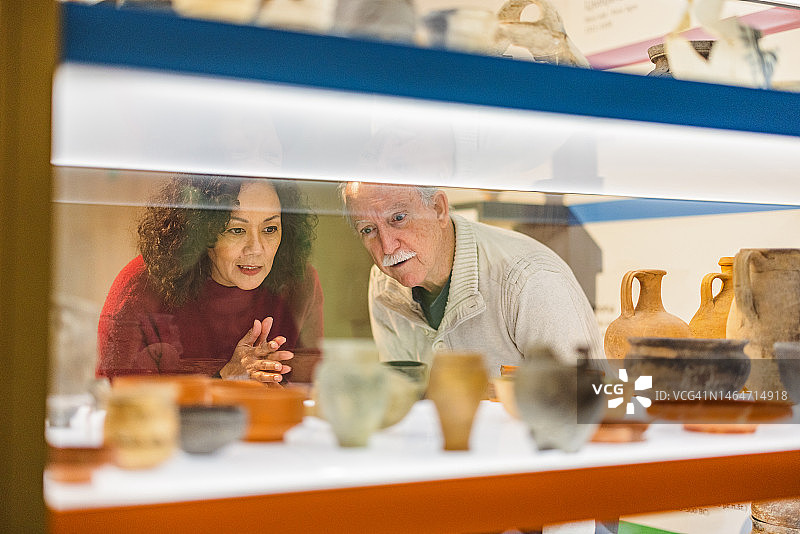 一对老夫妇在历史博物馆欣赏古老的陶器图片素材