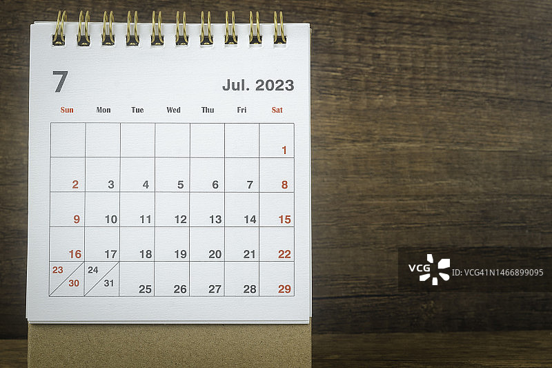 日历桌2023:7月是组织者计划和截止日期的月份，背景是木桌。图片素材