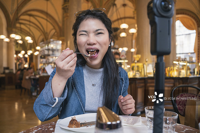 亚洲旅行视频博主介绍很棒的菜单著名餐厅，同时为社交视频视频社交媒体平台直播，社交媒体影响者在线视频咖啡馆，智能手机的食物图片素材