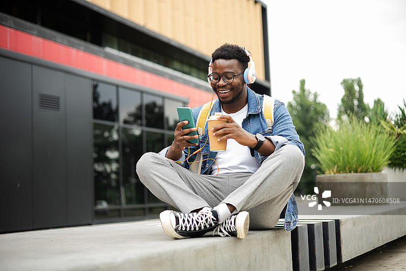 年轻的非洲裔美国学生在街上享受咖啡和音乐图片素材