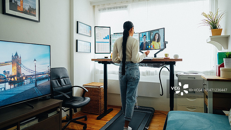 女人站在家庭办公室的办公桌上进行商务视频通话图片素材