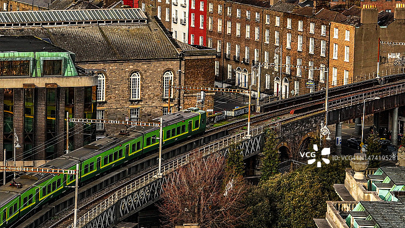 绿色Dart火车在爱尔兰都柏林的鸟瞰图，拥挤的城市生活鸟瞰图，欧洲城市中心，欧洲城市景观，空中拥挤的城市景观图片素材