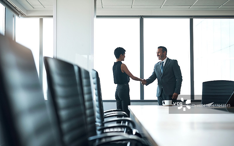 商务人士，握手和公司会议的伙伴关系，协作或问候在会议室。在b2b、交易或介绍中，商人与女商人握手图片素材