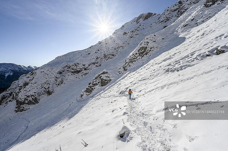 德国巴伐利亚，阿默高阿尔卑斯山脉，登山者在冬季积雪的徒步小径上，前往阿默高Hochplatte图片素材