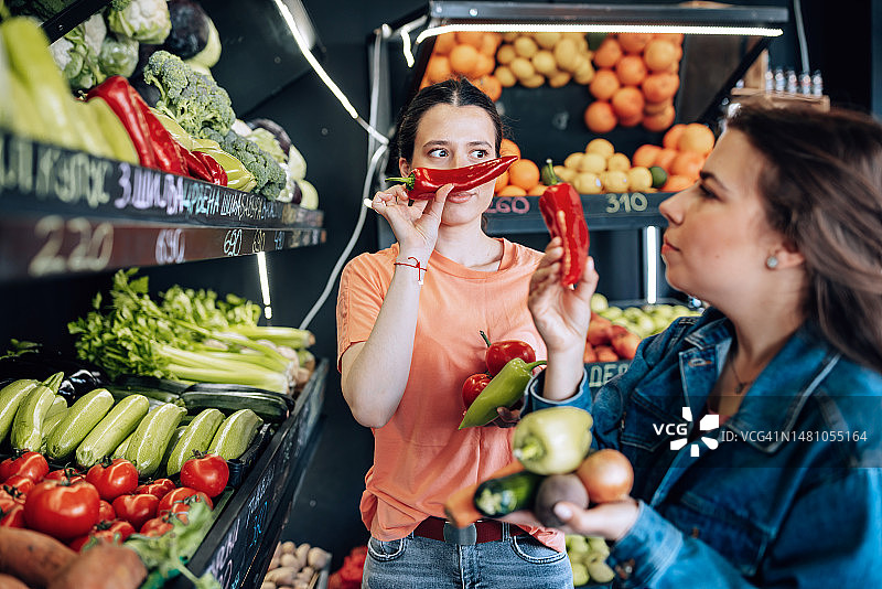 两名年轻女子称要购买的蔬菜图片素材