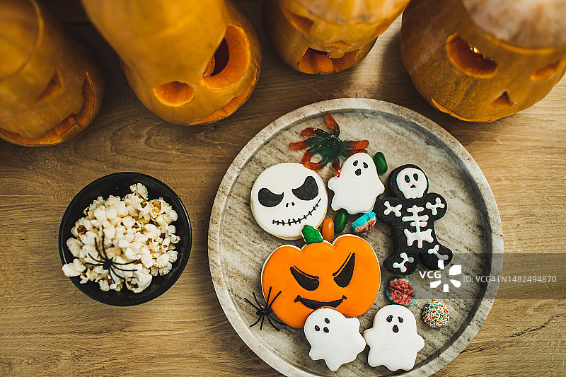 万圣节背景幽灵形状的饼干，爆米花和南瓜灯笼图片素材