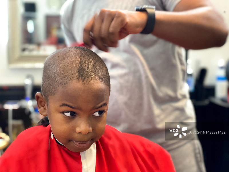 一个黑人小男孩在理发店理发图片素材