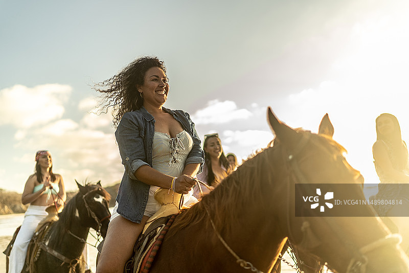 女性朋友在沙滩上骑马图片素材