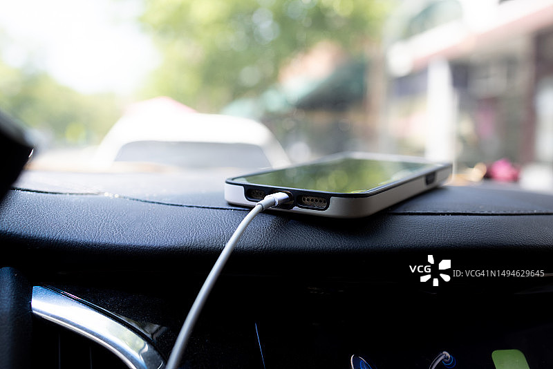 智能手机在汽车仪表盘上充电图片素材