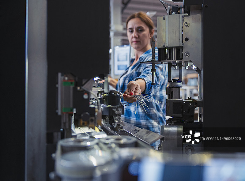 在工厂里操作制造设备的女工业工人图片素材