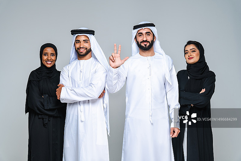 阿拉伯联合酋长国，一家人靠墙站着微笑的肖像图片素材