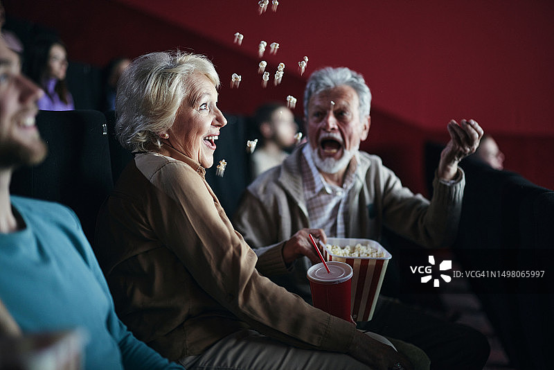 一对成熟的夫妇在电影院玩得很开心。图片素材