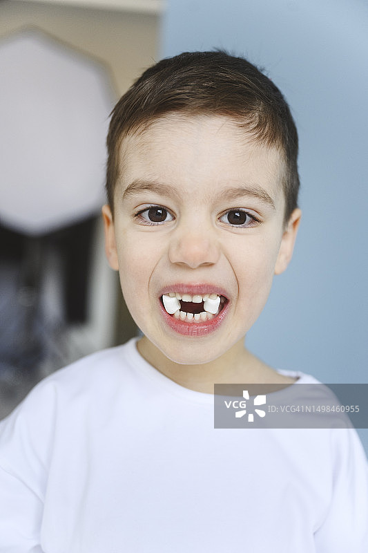 男孩用牙齿叼着棉花糖图片素材